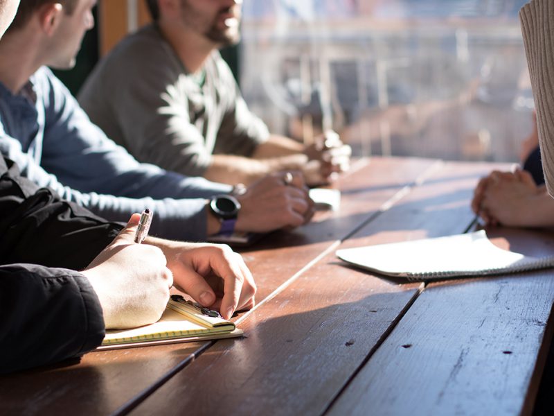 Three casually dressed employers interviewing potential employee