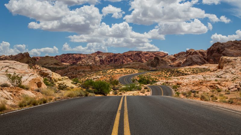 Difficult winding two-way road leading to beautiful desert mountain destination