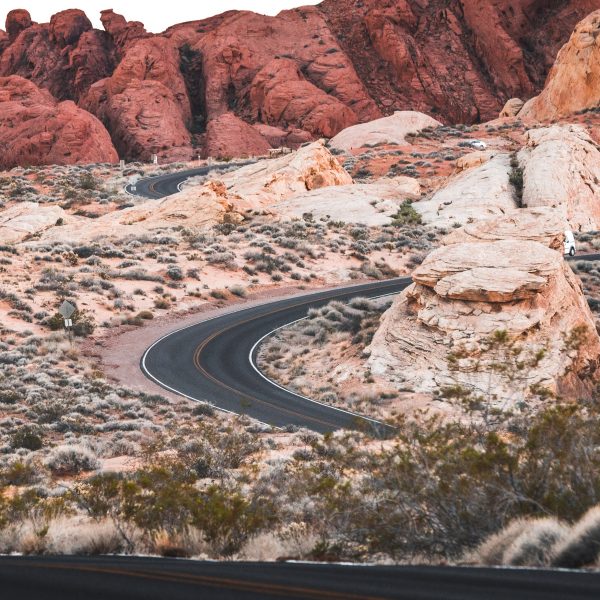 Difficult winding two-way road leading to beautiful orange-like desert mountain destination