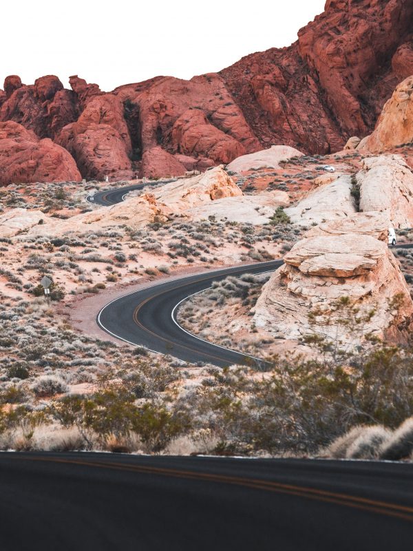 Difficult winding two-way road leading to beautiful orange-like desert mountain destination